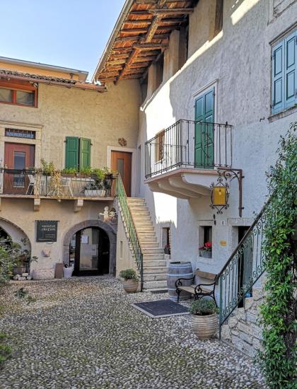 Rustic courtyard with climbing plants and external stairs.