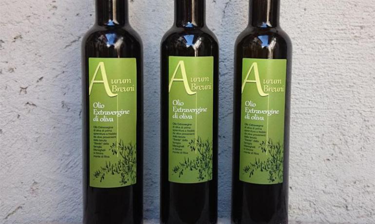 Three bottles of extra virgin olive oil with green labels.